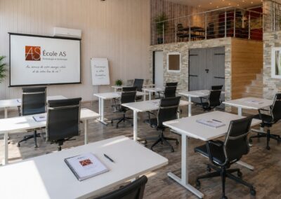 Salle de formation de l'École AS en Suisse romande avec postes de travail individuels pour les étudiants en kinésiologie.